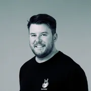 Adam Murphy — monochrome portrait, wearing a TourRadar t-shirt
